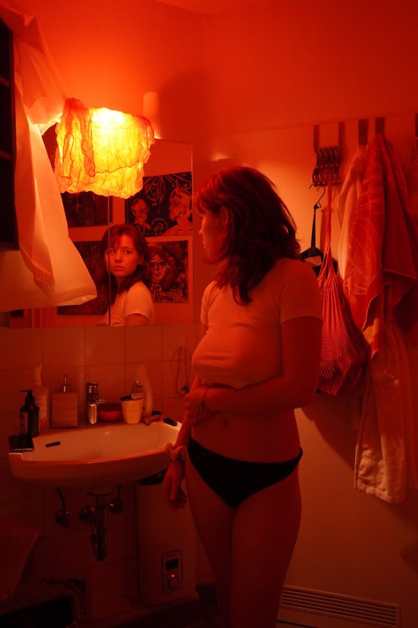 Ava schaut sich selbst im Spiegel an.