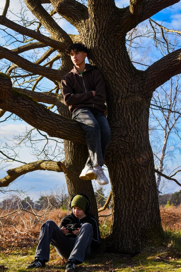 Die Freunde rasten an und auf einem Baum. Während Nelson nachdenklich in die Natur blickt und das Wetter genießt, ist Kian weiterhin starr mit seinem Handy beschäftigt.